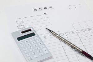 見積書と計算機とボールペンの写真